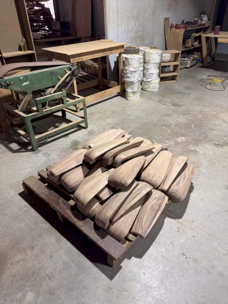 Custom black walnut chair seat blanks shaped and sanded, staged for assembly in the workshop