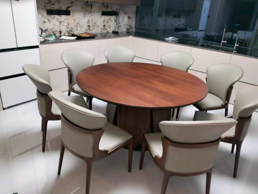 Second dining nook with a round solid walnut pedestal table and six upholstered chairs
